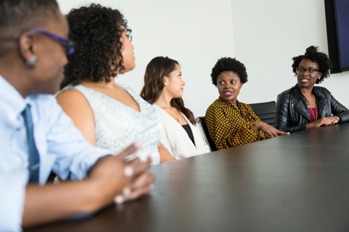 A group of women collaborating in a workplace meeting, designing strategy together