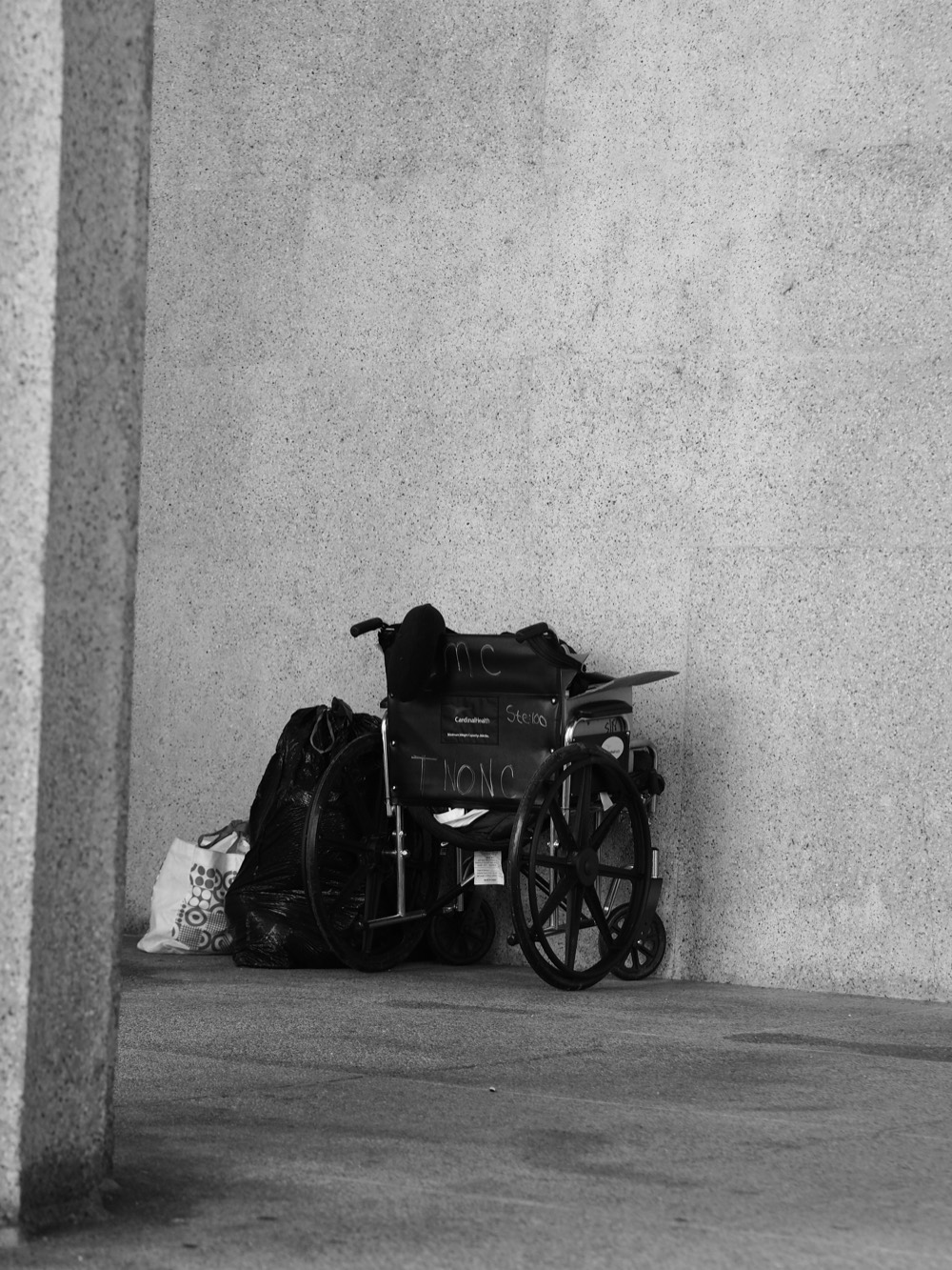 An empty wheelchair against a wall, a quiet image of accessibility and presence