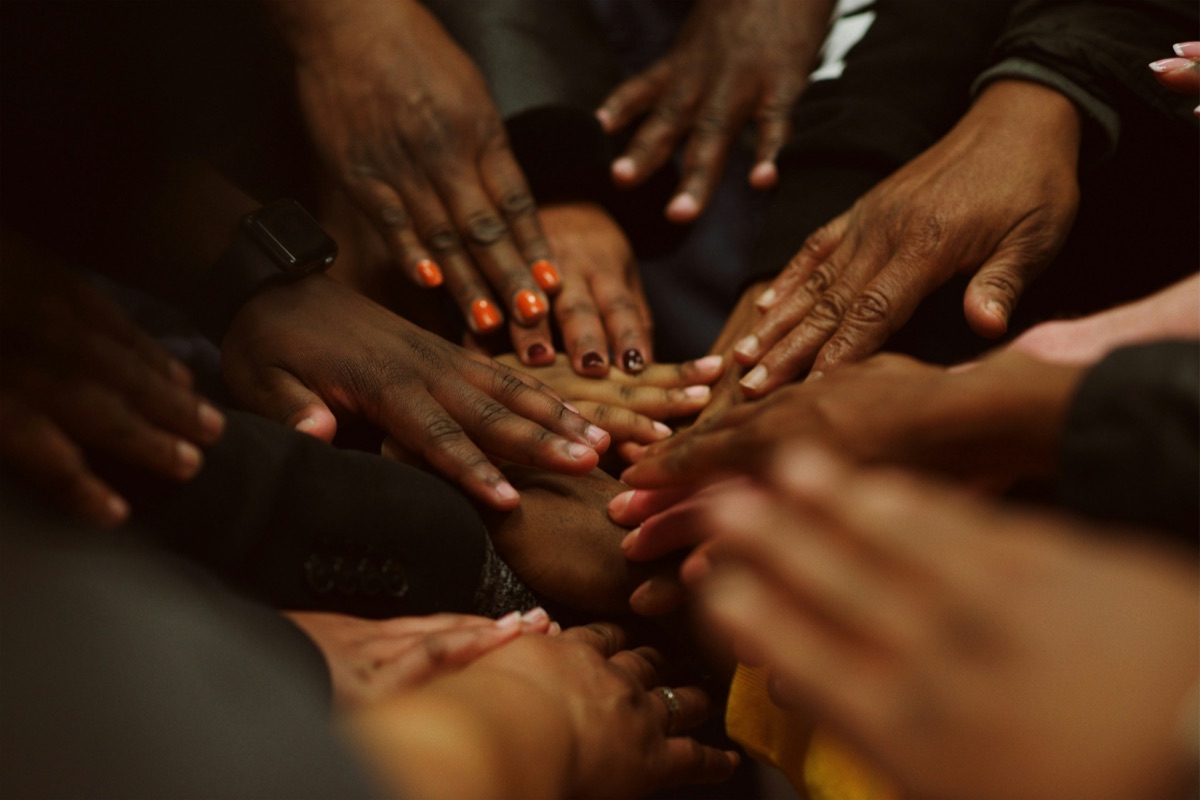 Diverse hands joined together in solidarity, symbolising the welcoming Mental Health Hub space
